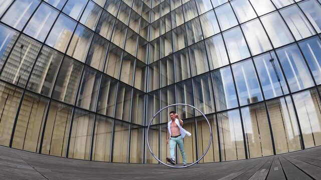 Dynamic and vibrant performance of a Cyr Wheel within urban architecture. Concept of individuality, creativity and self-confidence