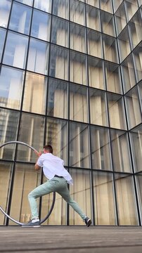 Dynamic and vibrant performance of a Cyr Wheel within urban architecture, vertical video. Concept of expression, freedom, passion and potential