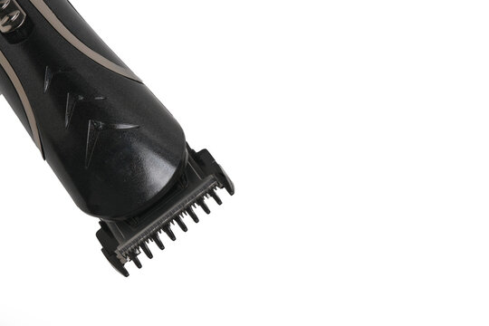 Close up view black electric hair clipper head and blade set against white background.