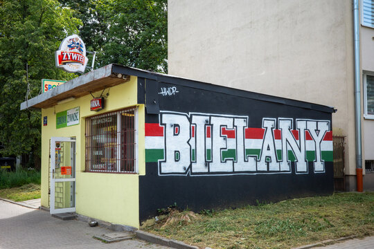 Warsaw, Masovian Voivodeship, Poland - August 13 2026: A small local grocery shop features prominent district graffiti art on its side wall.