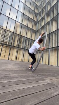 Dynamic and vibrant performance of a Cyr Wheel within urban architecture, vertical video. Concept of expression, freedom, passion and potential