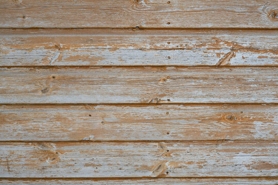 Weathered painted wood texture background with faded orange paint and exposed grey timber