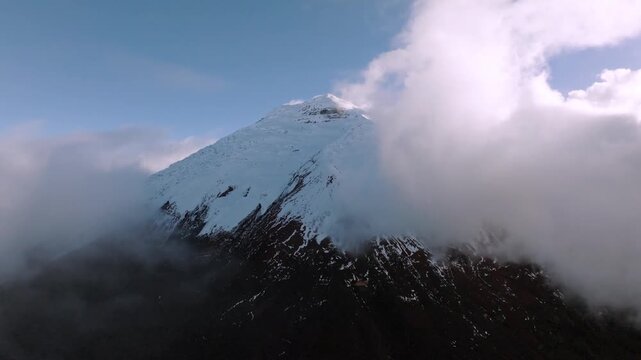 Aerial Shot of Snow Covered Volcanic Mountain Peak Shrouded in Clouds