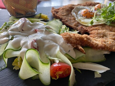 Wiener Schnitzel vom Kalb mit Spiegelei, frischem Salat und knusprigen Pommes frites. Klassisches Restaurantgericht, &ouml;sterreichische K&uuml;che, Hausmannskost und authentische Food-Fotografie.