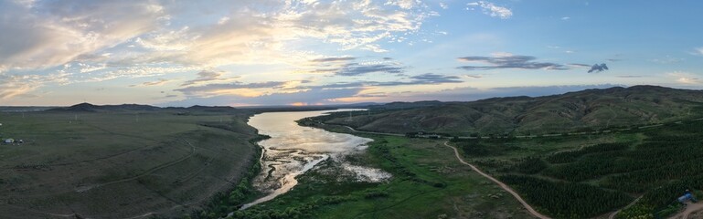Fototapeta premium Beautiful sunset scenery of Xilingol National Wetland Park in Inner Mongolia. Golden twilight glow over wetland water surface, natural wetland ecological landscape at dusk.