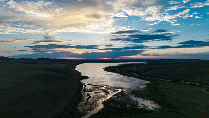 Fototapeta premium Beautiful sunset scenery of Xilingol National Wetland Park in Inner Mongolia. Golden twilight glow over wetland water surface, natural wetland ecological landscape at dusk.
