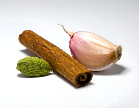Sliced garlic with cinnamon on white background