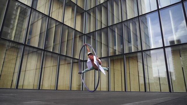 Dynamic and vibrant performance of a Cyr Wheel within urban architecture. Concept of expression, freedom, passion and potential