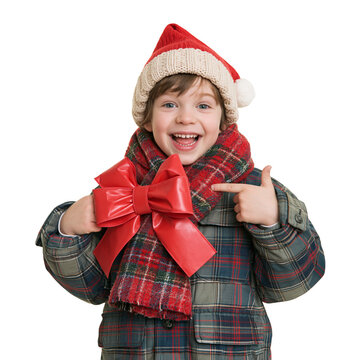 Excited little boy in santa hat pointing at big red bow on his scarf isolated on transparent or white background, png