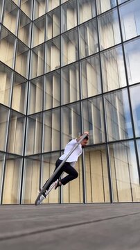 Dynamic and vibrant performance of a Cyr Wheel within urban architecture, vertical video. Concept of expression, freedom, passion and potential