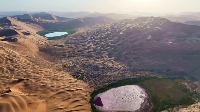 Turquoise Oasis Lake Surrounded by Golden Sand Dunes in Badain Jaran Desert, China