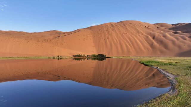 Turquoise Oasis Lake Surrounded by Golden Sand Dunes in Badain Jaran Desert, China