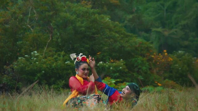 Playful Interaction of Indonesian Dancers Lying and Sitting in Grass