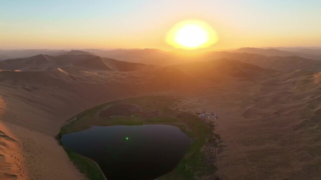 Turquoise Oasis Lake Surrounded by Golden Sand Dunes in sunrise in Badain Jaran Desert, China