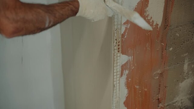 Construction worker plastering an interior wall