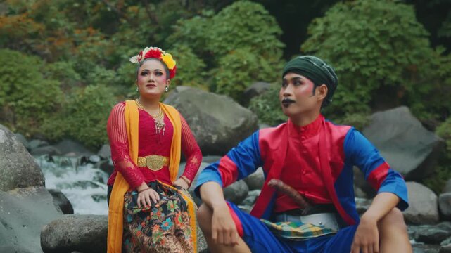 Two Traditional Javanese Dancers Sitting by the River Stream