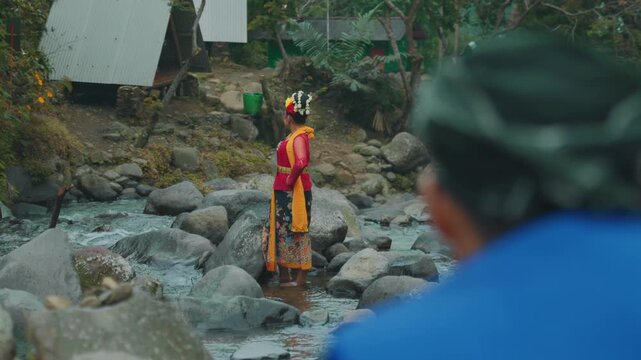Indonesian Dancer Standing in River with Male Observer
