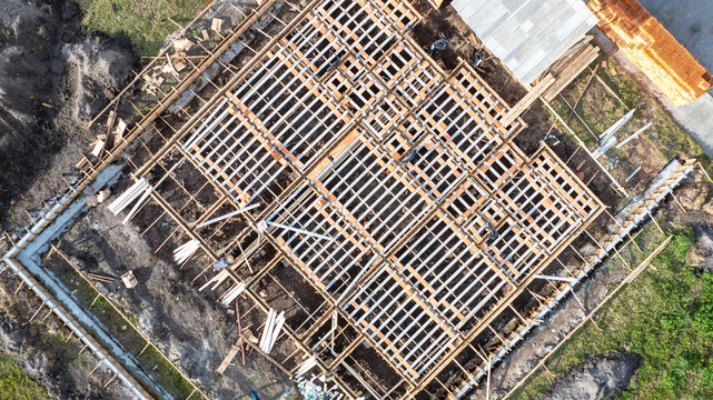 Aerial view of a residential construction site featuring pre-cast concrete structures and workers on the ground in Florianopolis, Santa Catarina, Brazil.