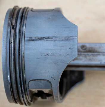 Four stroke engine piston damaged by low engine oil showing oil starvation and piston skirt damage