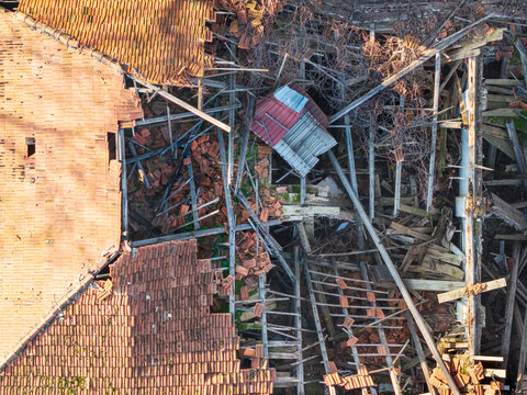 Aerial view of the collapsed roof structure of a fire-damaged building with broken tiles and exposed wooden beams in Belgrade, Serbia.