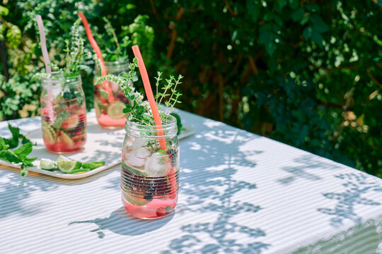 Berry herbal lemonade refreshing cold summer mocktail. Infused water with citrus, berries and fresh mint. Detox drink.