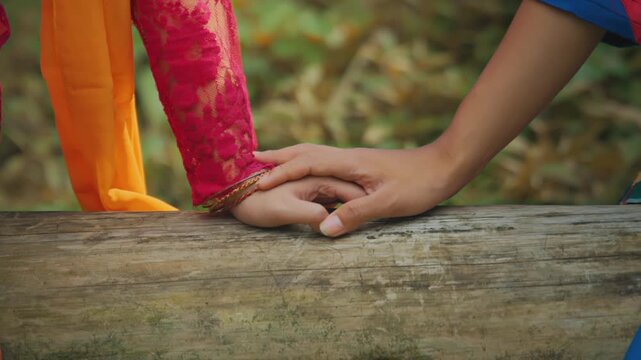 Playful Hand Interaction Between Couple on Wooden Log