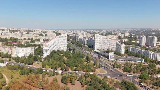 Aerial drone approach toward the Gates of Chisinau residential buildings on Dacia Boulevard, showing urban traffic, apartment blocks and the Botanica district of Chisinau, Moldova.
