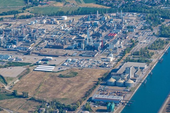 Aerial view of the industrial complex and refinery with storage tanks, pipelines, and adjacent canal in Hombourg, Grand Est, France.