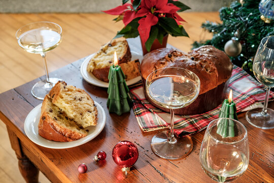 Festive Christmas Table With Panettone, Champagne Glasses, Poinsettia and Candles for Holiday Celebration
