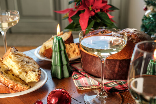 Festive Christmas Table With Panettone, Champagne Glasses, Candles and Poinsettia Centerpiece for Holiday Celebration