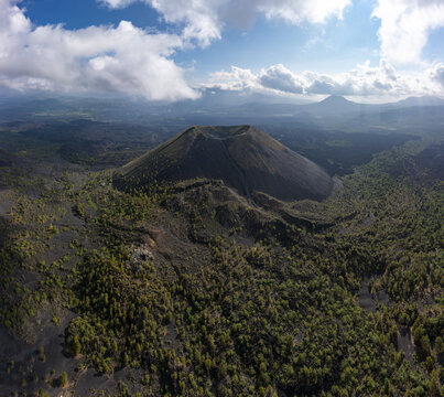 Aerial view of the Paricutin volcano featuring its distinct conical shape surrounded by volcanic terrain and lush forest in San Juan Parangaricutiro, Michoacan, Mexico.