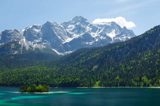 Travel landscape of Zugspitze Alps in Bavaria, Germany, scenic summer nature panorama with forest, Eibsee lake, snow mountains peak. Alpine landscape
