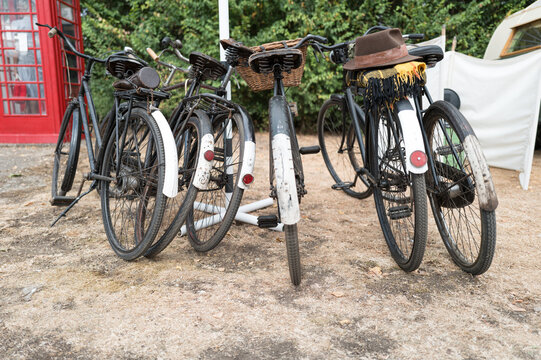 Selection of 1940s era bicycles seen near an old British style red telephone box. Attire from the era can be seen on one of the bicycles.