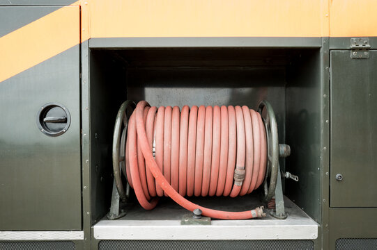 Abstract view of a water house reel seen coiled up at a side bay of an old British Green goddess fire engine. Still in use today, as an emergency fire tender in times of national emergency.