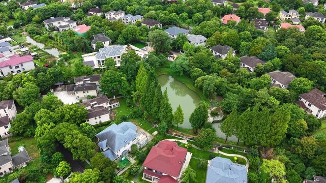 Aerial top‑down view of green‑surrounded suburban villa residential area	