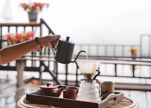 Making fresh drip coffee with foggy mountain background