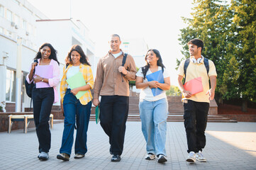 Obraz premium Diverse students walking on campus during break
