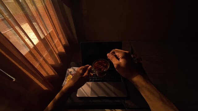 POV of stirring coffee in a cup sitting at a laptop desk during a cozy sunny morning, slow motion 4K 120fps