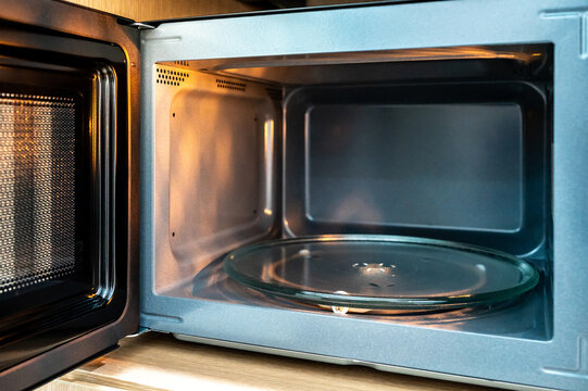 Empty microwave oven with open door. Inside of a modern microwave. Home appliance in the kitchen