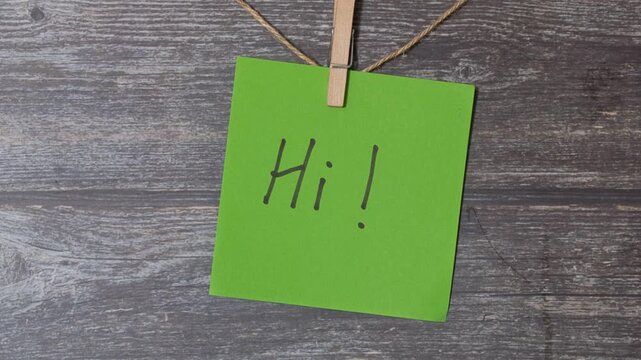 green slip of paper with the written message of hi
