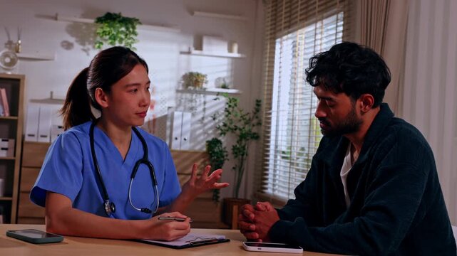 Doctor patient consultation clinic healthcare medical stethoscope clipboard discussion indoor woman man caregiver adult male bright office calm serious mood