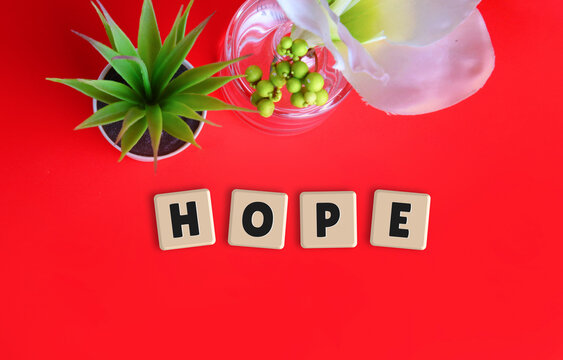Hope Word Spelled in Wooden Letter Tiles on Red Background