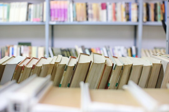 stack of books against the background of library, stack of books in front of library, books on wooden table, education, High quality book photography, Best Book Photo
