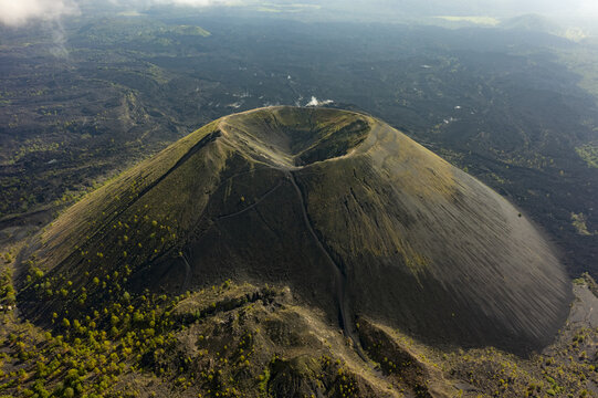 Aerial view of Paricutin volcano with volcanic cone and crater surrounded by solidified lava fields and patches of green vegetation, San Juan Parangaricutiro, Michoacan, Mexico.