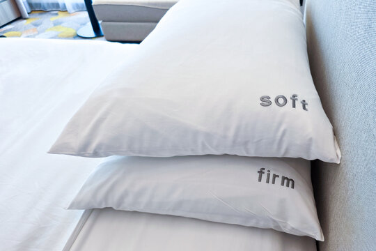 Firm and soft pillow alternatives placed on bed for hotel room guests to choose in accordance to preference for a comfortable sleep