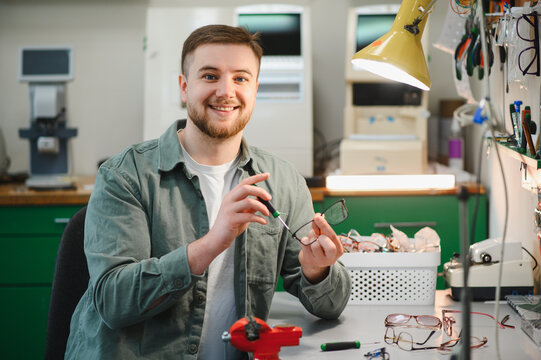 Optician technician repairing eyeglasses in workshop