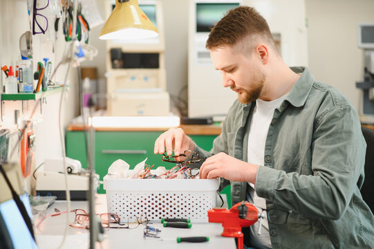 Optician repairing eyeglasses in a workshop