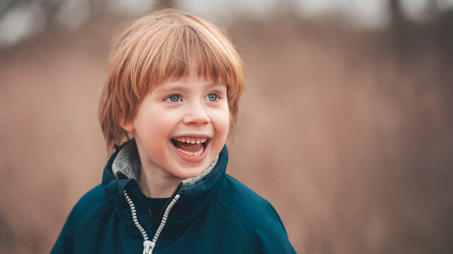 Laughing Redhead Boy in Teal Jacket Outdoor Winter Portrait