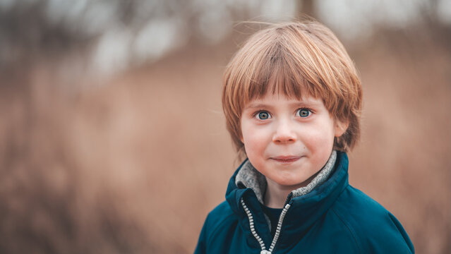 Blue-Eyed Boy in Teal Jacket Portrait with Copy Space
