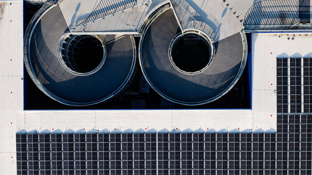 Aerial view of the circular ramps of a parking garage integrated with extensive solar panel arrays on the rooftop in Delft, South Holland, Netherlands.